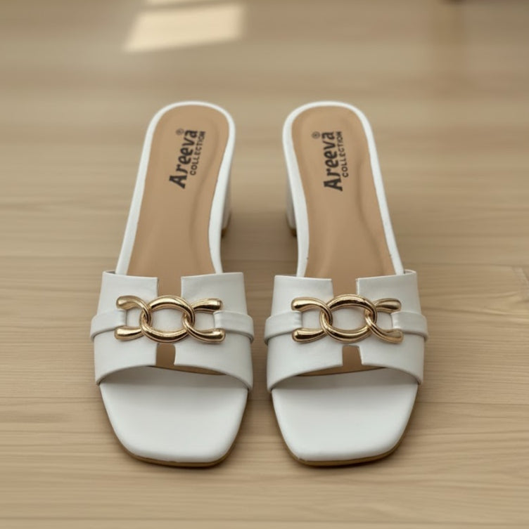 White sandals with gold buckles on a wooden surface, featuring the Areeva Collection brand.