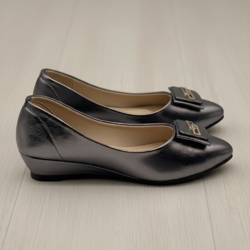 Pair of grey shoes with bow details on a light wooden floor.