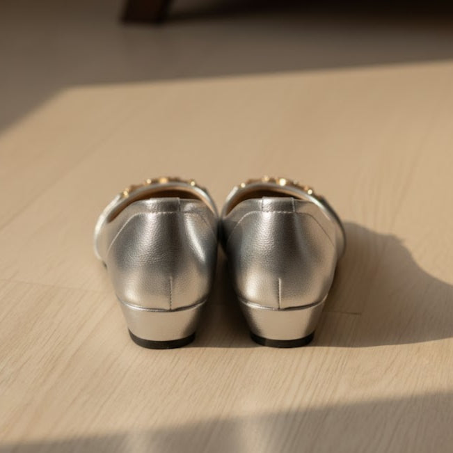 Pair of silver shoes on a wooden surface