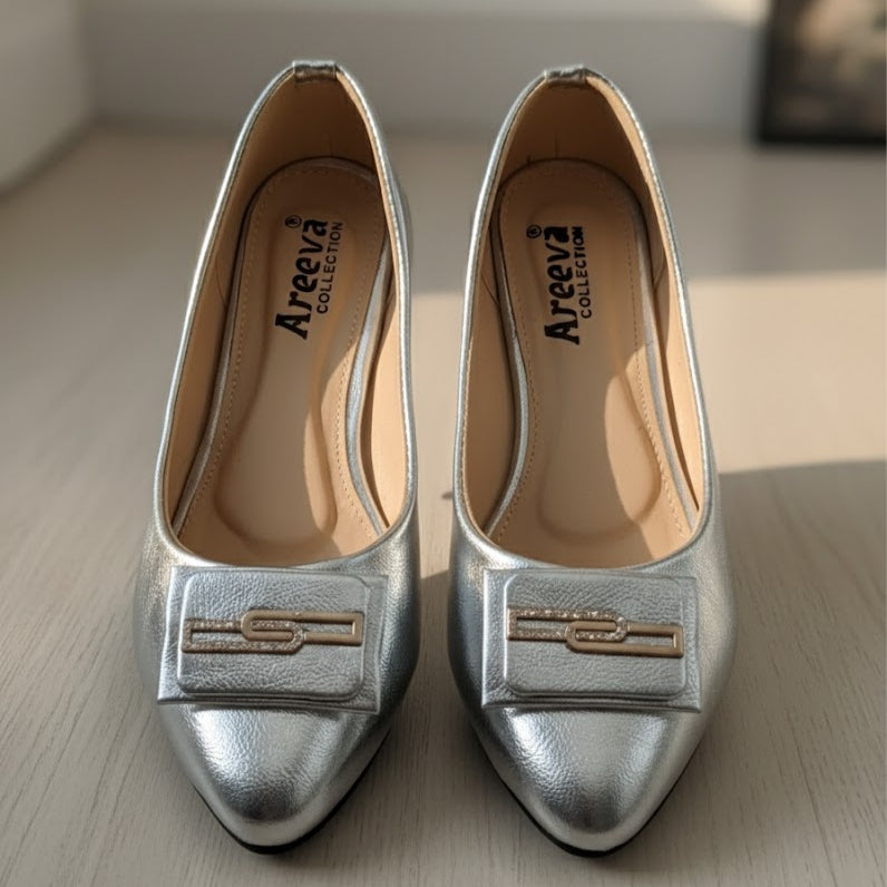 Pair of silver shoes with a visible brand logo on a light wooden surface.