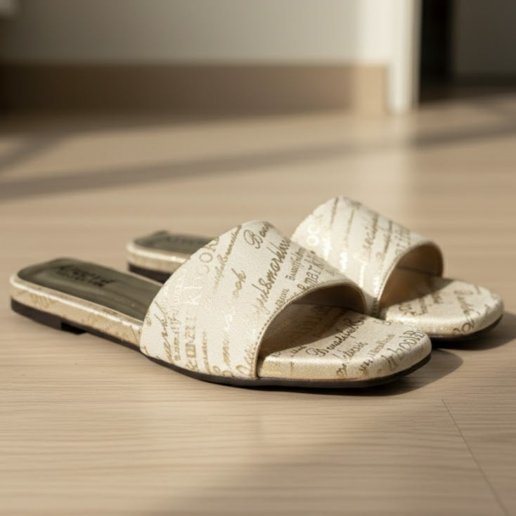 Pair of open-toe sandals with text pattern on a wooden floor