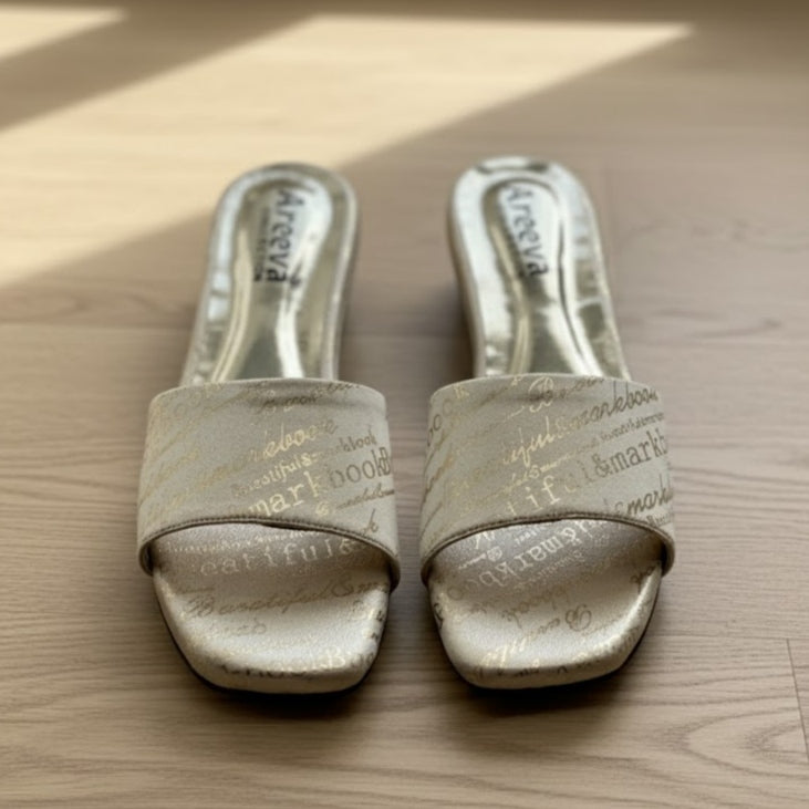 Pair of beige slipper shoes on a wooden surface