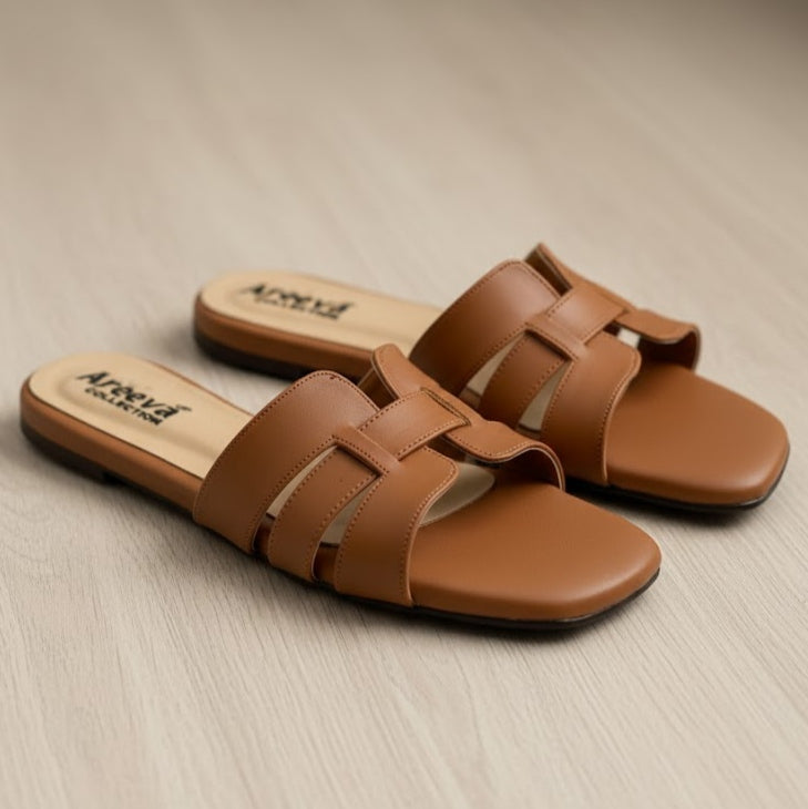 Pair of brown sandals on a beige surface