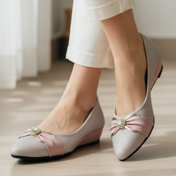 pink shoes with pink accents worn by a person on a light wooden floor.