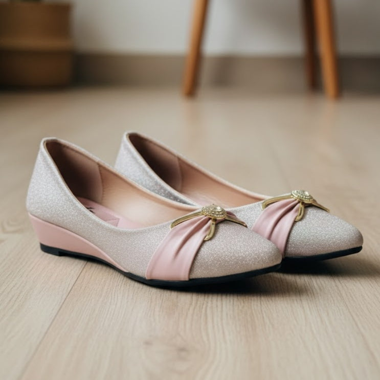 Pair of pink shoes with pink bows on a wooden floor