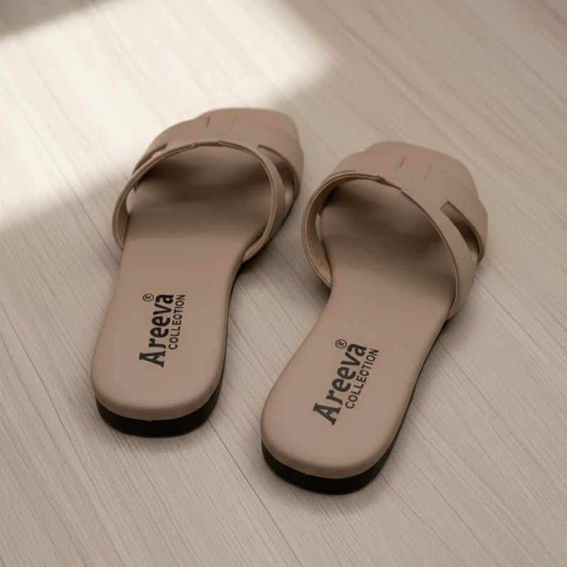 Pair of beige sandals with 'Areeva Collection' branding on a light wooden floor.