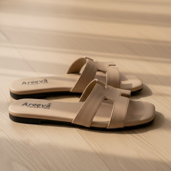 Pair of beige sandals with 'Areeva' branding on a wooden surface