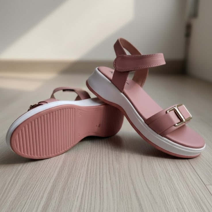 Pink sandals with white soles on a wooden floor