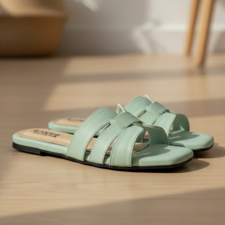 Pair of light green sandals on a wooden floor
