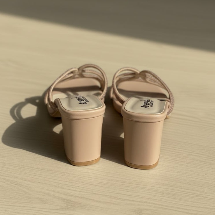 Pair of beige sandals on a textured surface