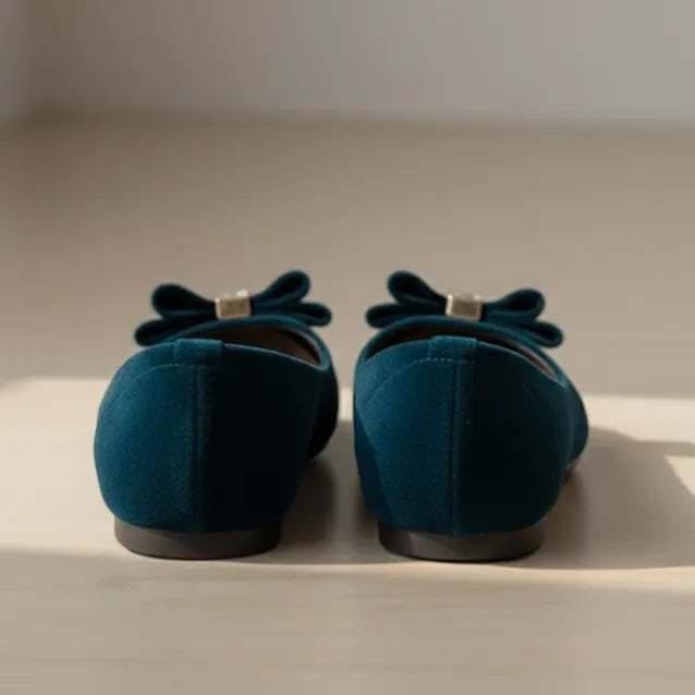 Pair of blue shoes with bows on a light surface