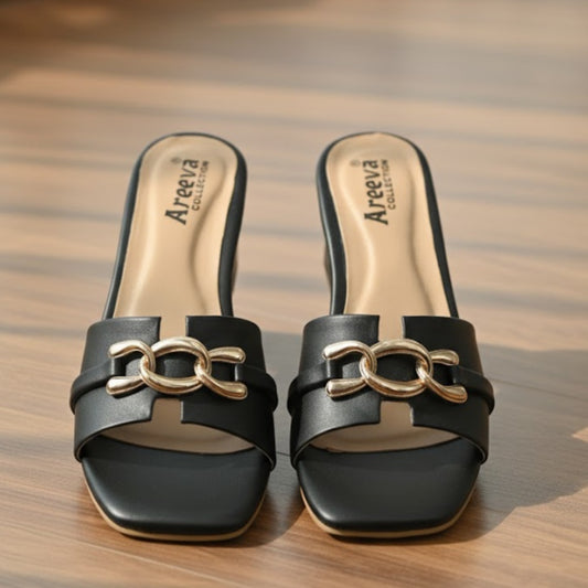 Black sandals with gold chain detail on a wooden surface, featuring the Areeva brand.