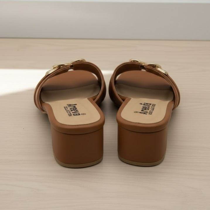 Pair of brown sandals with visible brand name on a light wooden surface