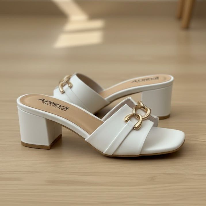 White heeled sandal with a gold bow on a light gray background