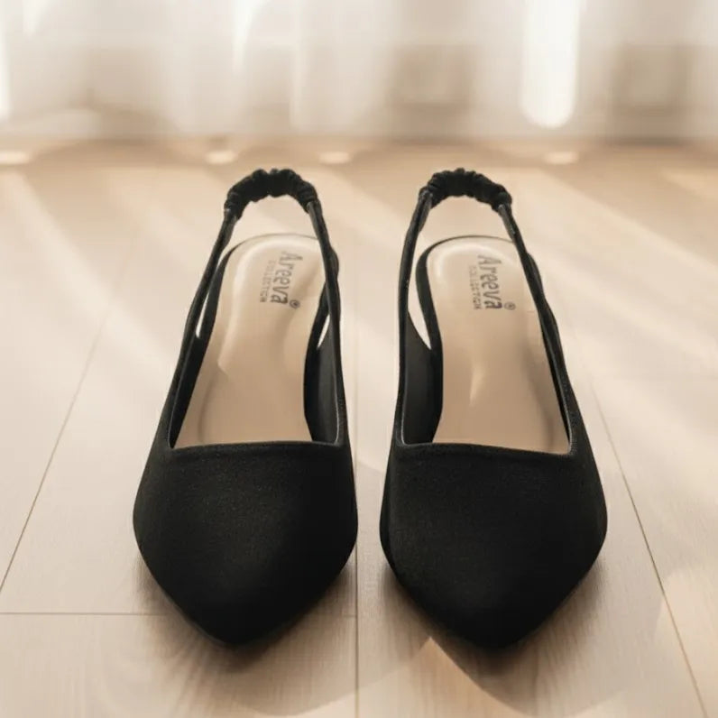 Pair of black high-heeled shoes on a light wooden floor