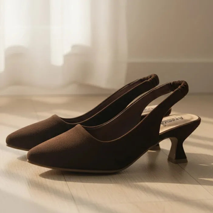 Pair of brown high-heeled shoes on a wooden floor with a blurred background