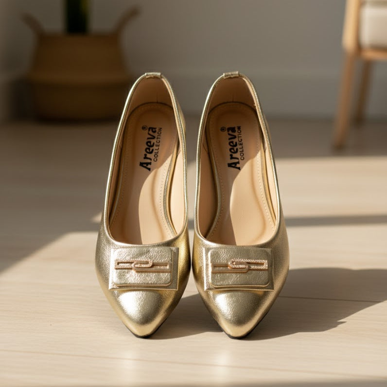 Pair of gold shoes with 'Areeva' branding on a wooden surface.