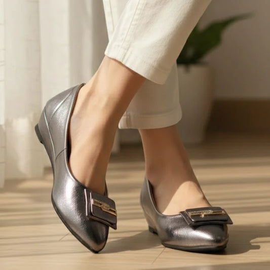 Gray Stylish shoes with a bow detail worn by a person on a wooden floor.