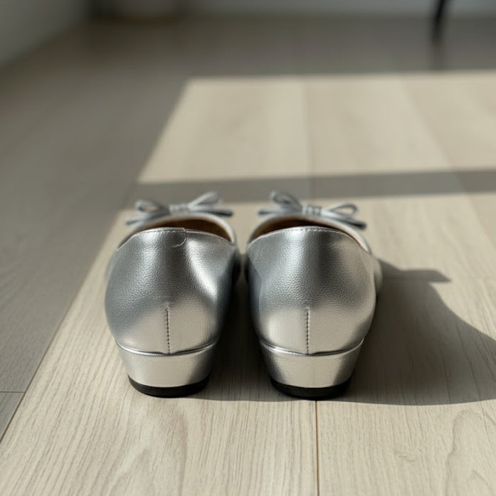 Pair of silver loafers on a wooden floor