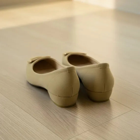 Pair of beige shoes on a wooden floor