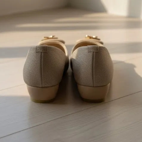 Pair of beige shoes on a light wooden floor