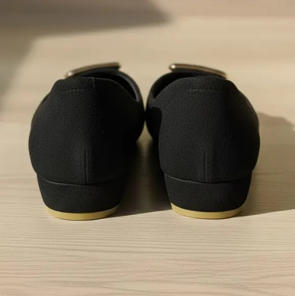 Pair of black loafers on a wooden surface