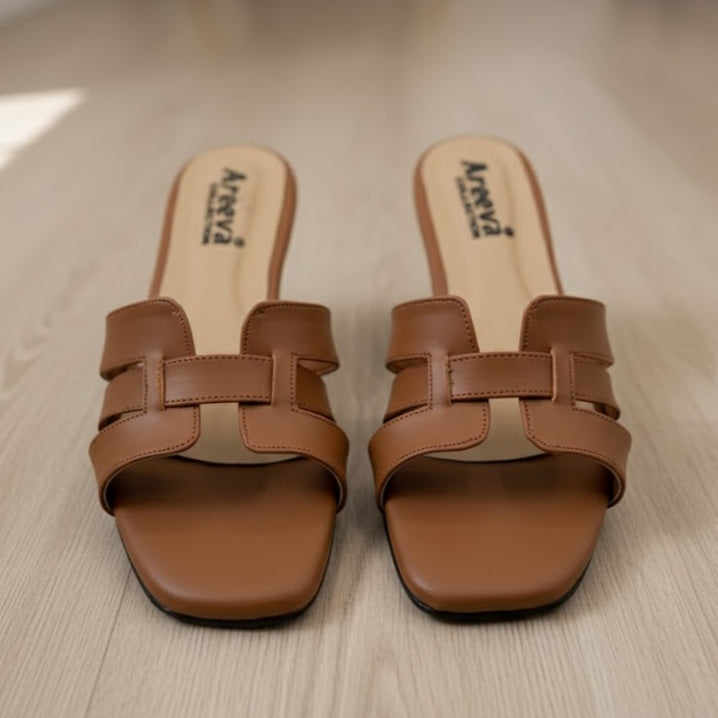 Pair of brown sandals with 'Areva' branding on a light wooden floor.