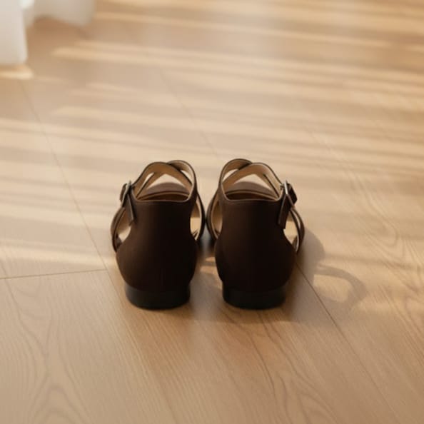 Pair of brown sandals on a wooden floor
