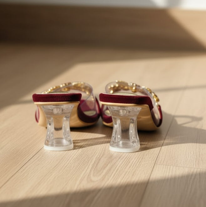 Pair of high-heeled shoes with clear stands on a wooden surface