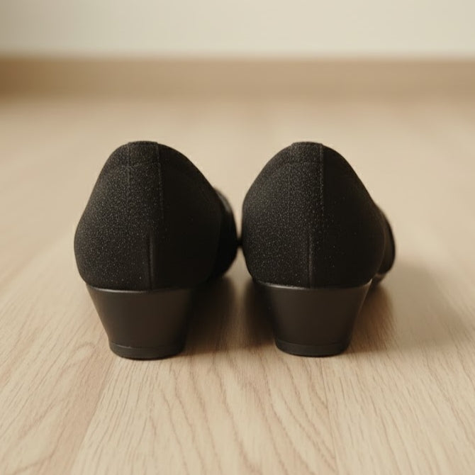 Pair of black shoes on a wooden floor