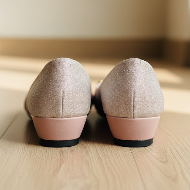 Pair of pink shoes with pink soles on a wooden floor