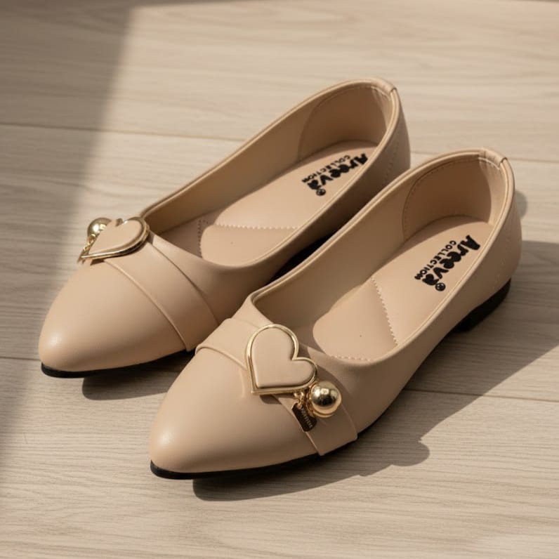 Pair of beige shoes with heart-shaped embellishments on a wooden surface