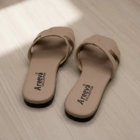Pair of beige Flipper with Areeva branding on a light wooden floor.