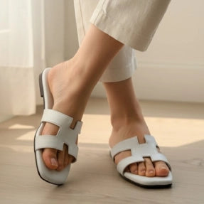 White Fipper worn by a person on a light wooden floor.