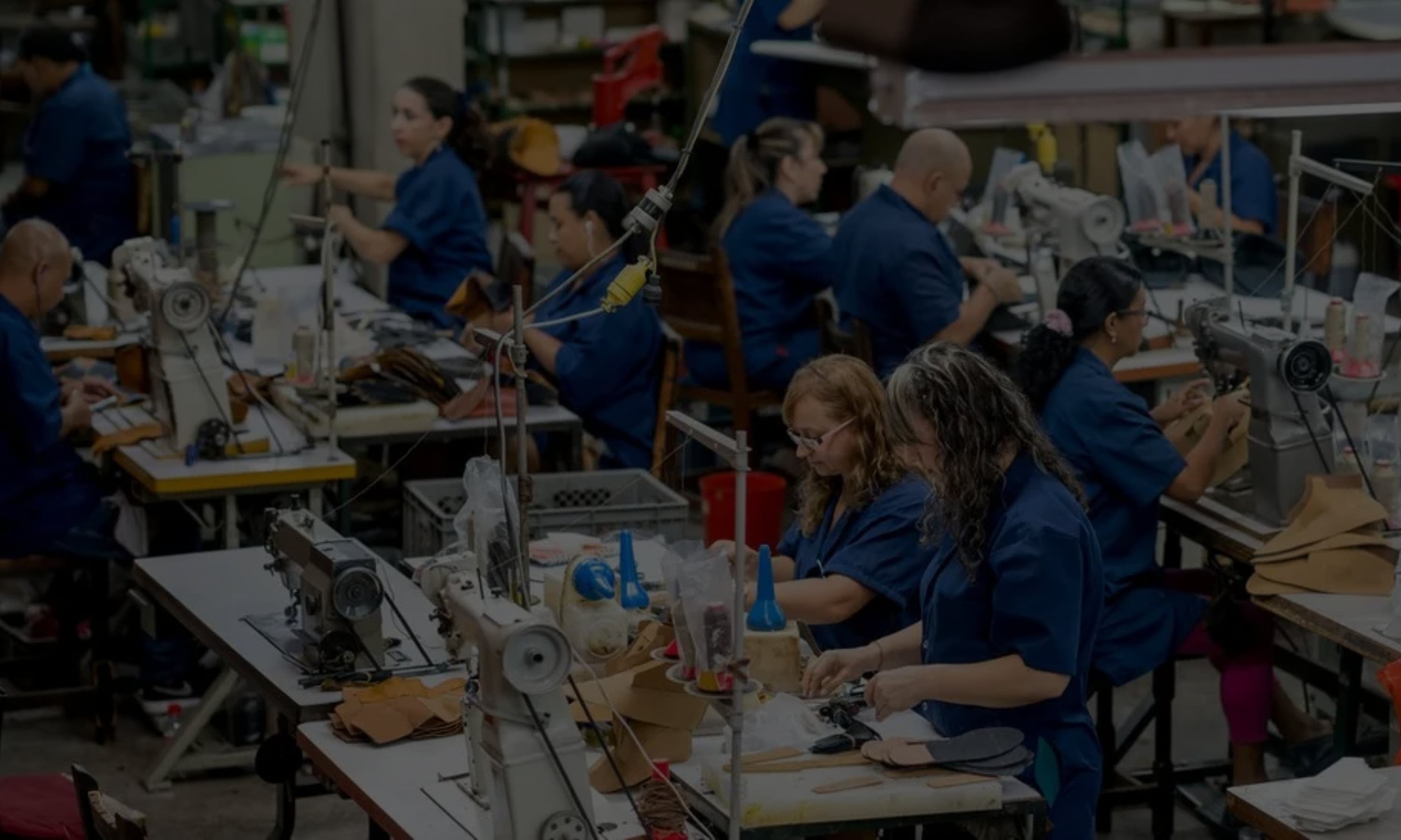 Factory floor with workers operating sewing machines.