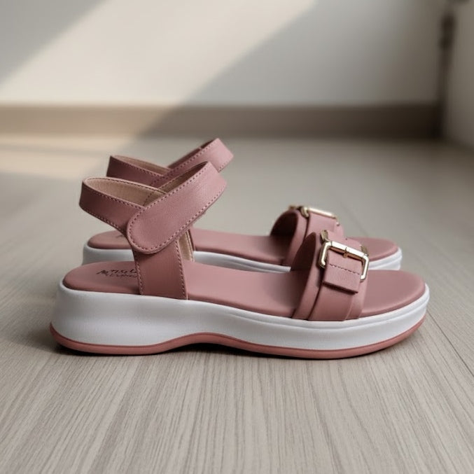 Pink sandals with white soles on a wooden floor