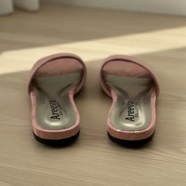 Pair of pink slippers with 'Areeva' branding on a wooden floor.
