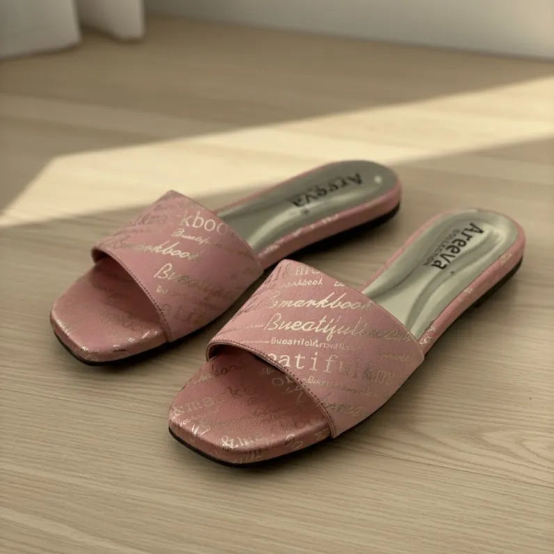 Pair of pink slides with text on a wooden floor